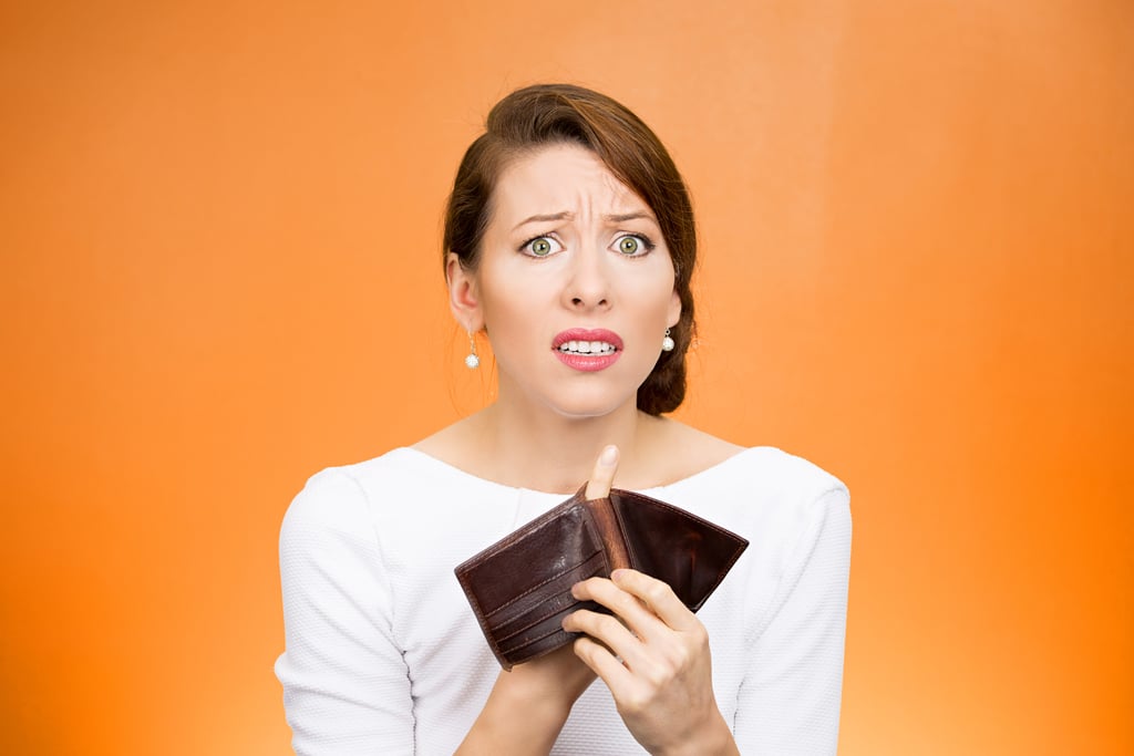 Frustrated woman who is losing business because she doesn't have a website with finger through empty wallet