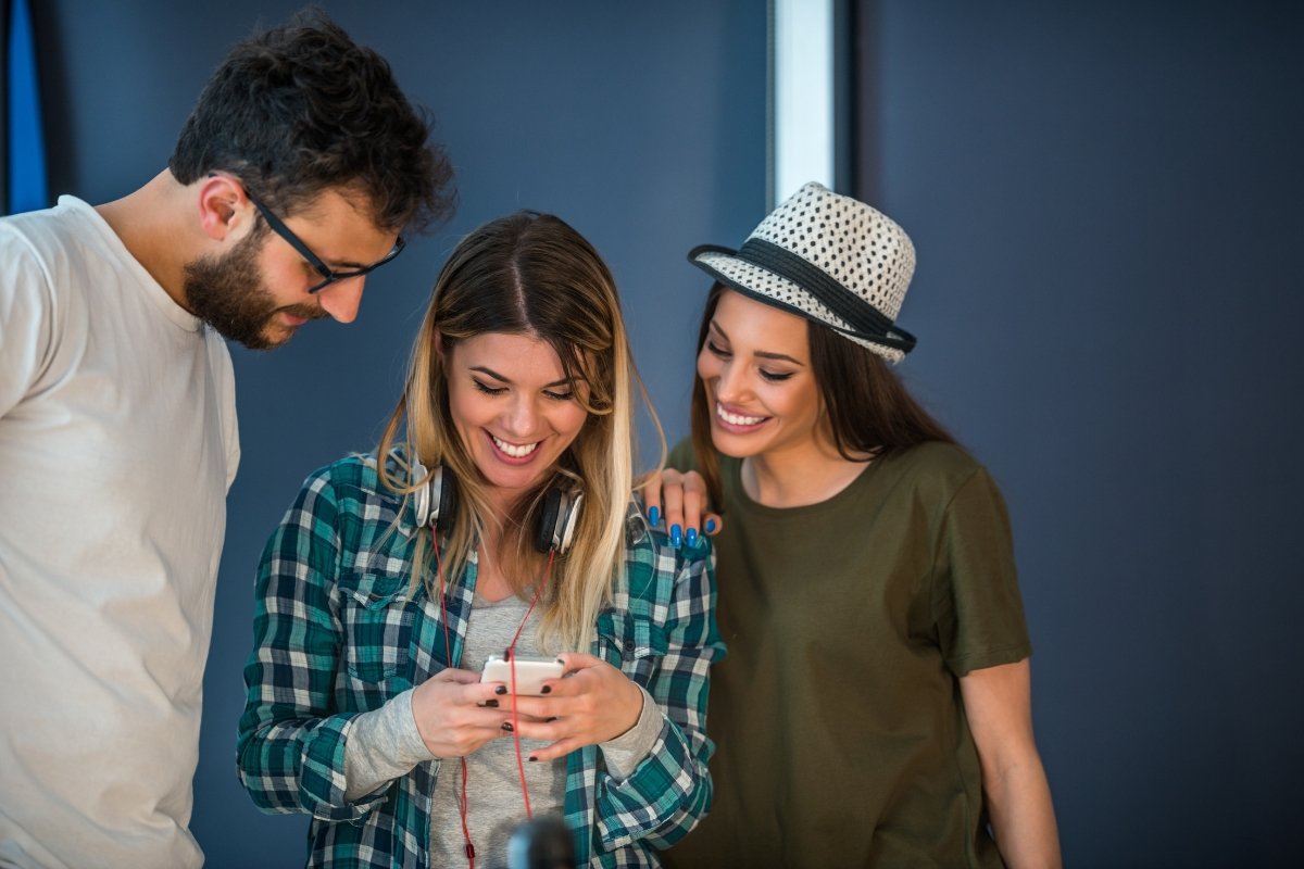 A group of people engaged in social media trends while looking at a cell phone.