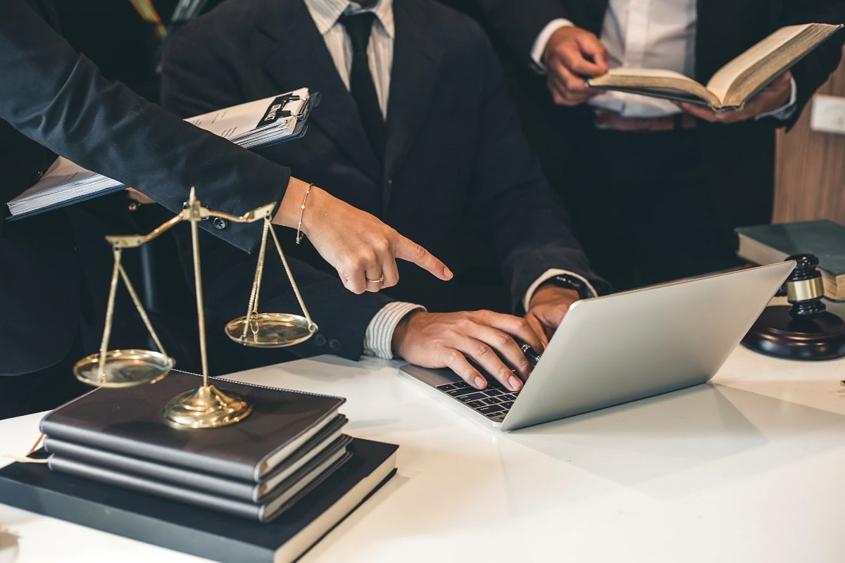 A group of lawyers utilizing laptops in a courtroom while managing their Google Local Service Ads.