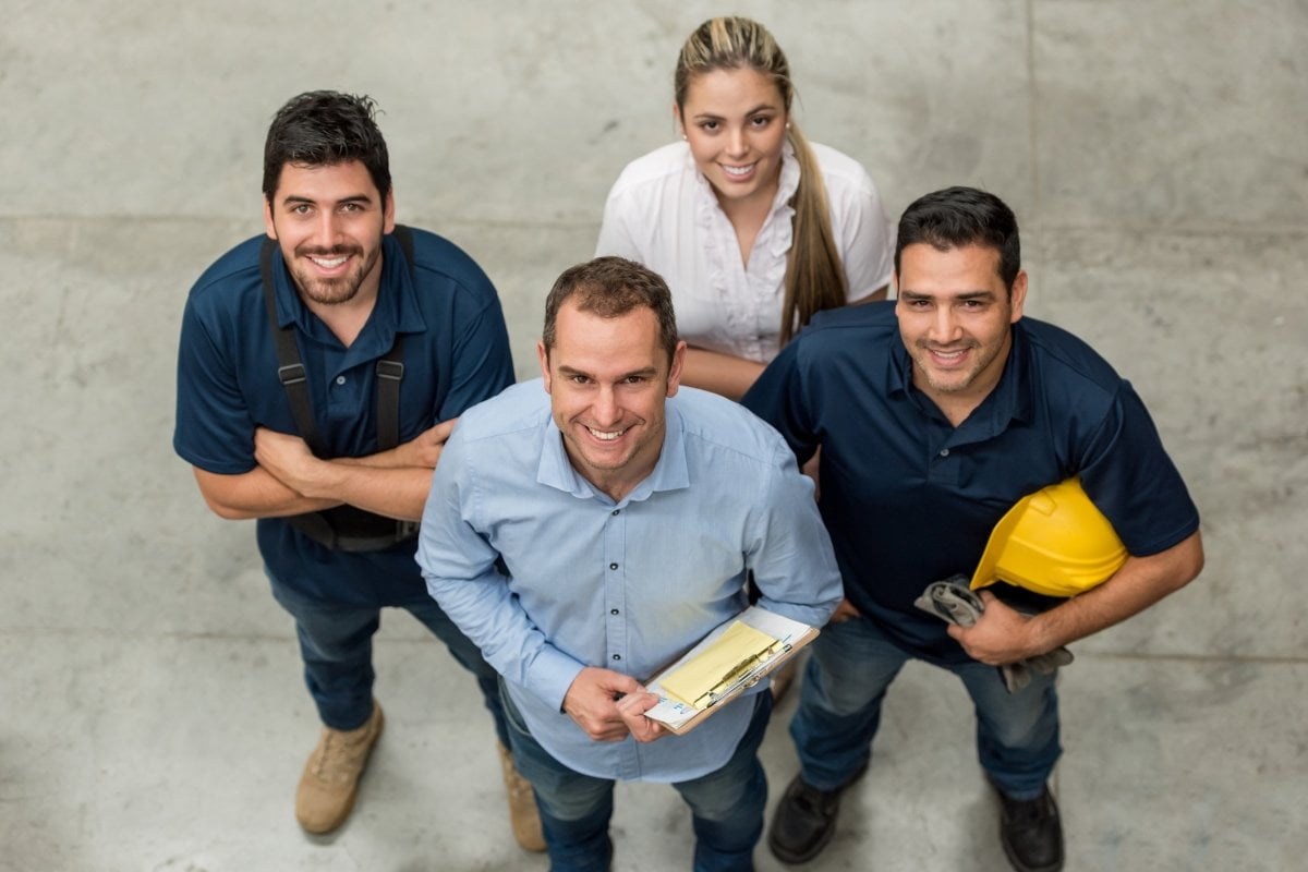 A group of construction workers from various home service businesses posing for a photo.