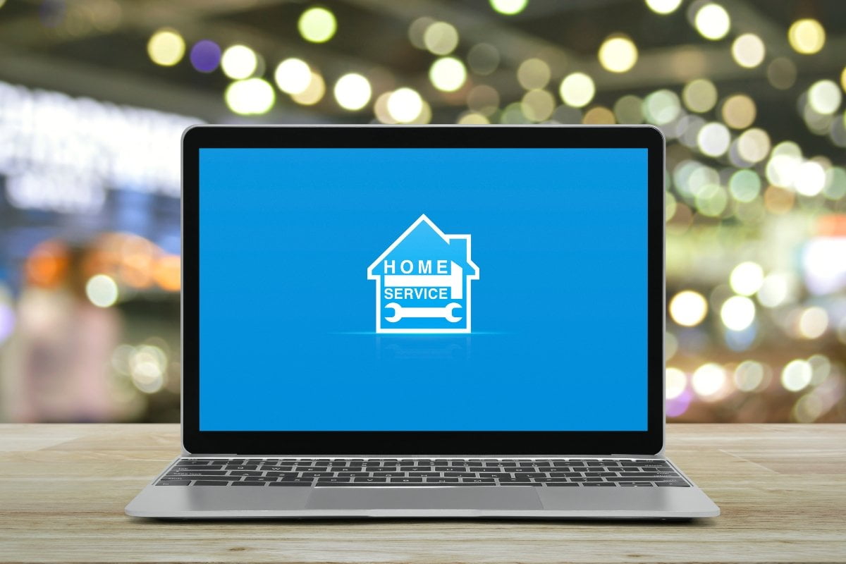 A service-based business using marketing strategies featuring a laptop with a house logo on a wooden table.