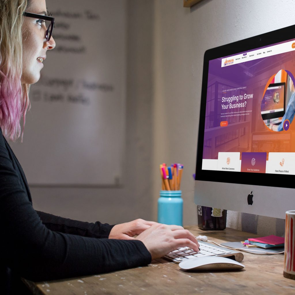 A marketing expert is sitting at a desk using a computer.