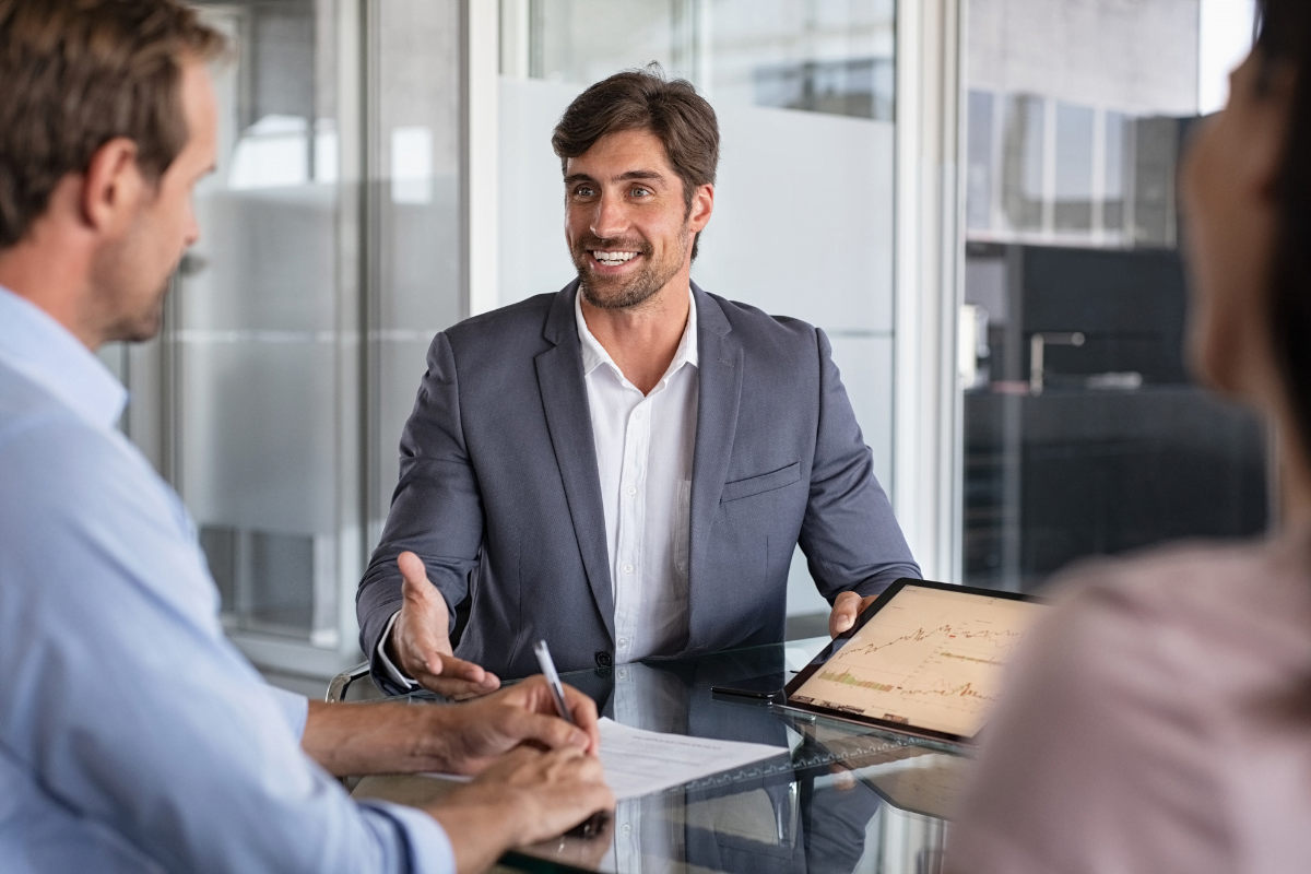 Two business people discussing the possibility of hiring an SEO consultant at a table in an office.