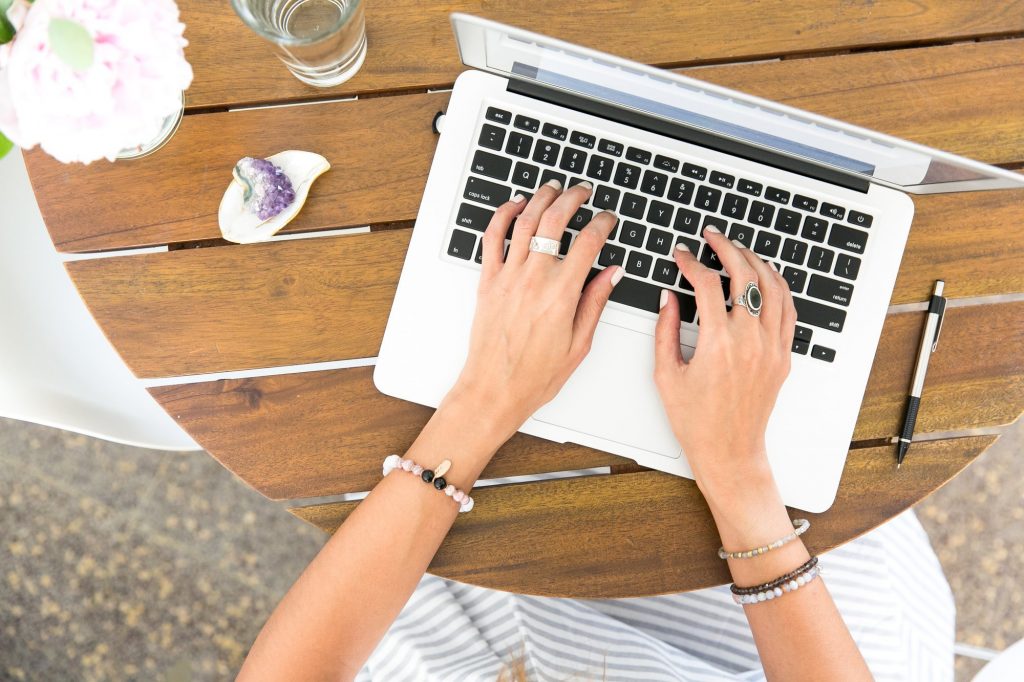 A woman creating evergreen content on her laptop at a table.