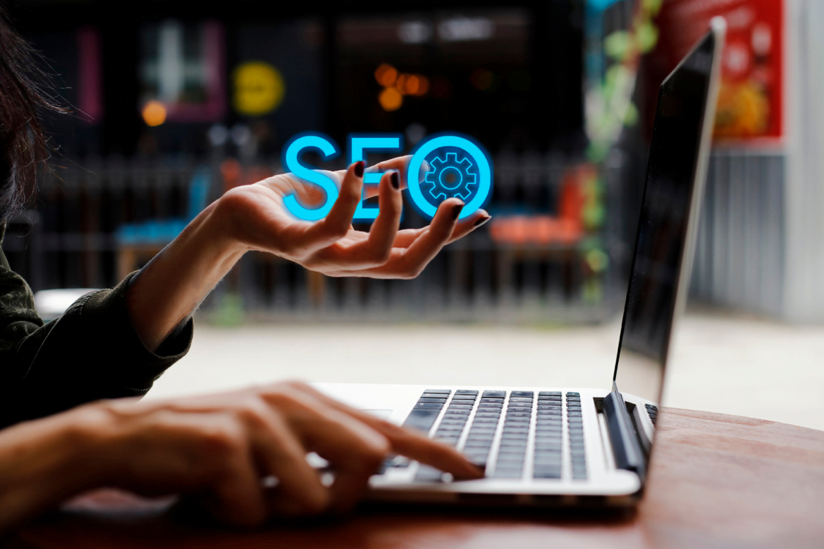 A woman using a laptop with the word SEO on it, providing SEO for lawyers services.