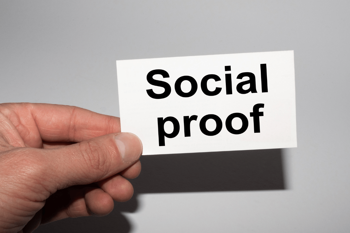 A person demonstrating social proof by holding up a small card.