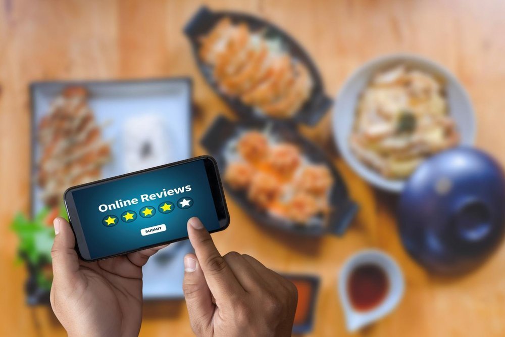Boost Your Catering SEO with Stellar Reviews 3 A person holding a smartphone displaying an online rating of 5.