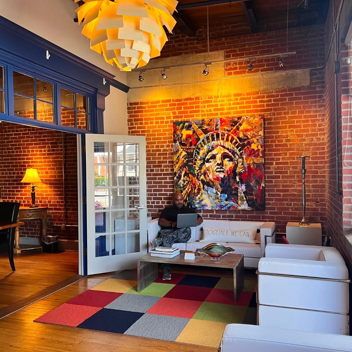 A vibrant living room featuring a colorful rug and charming brick walls.
