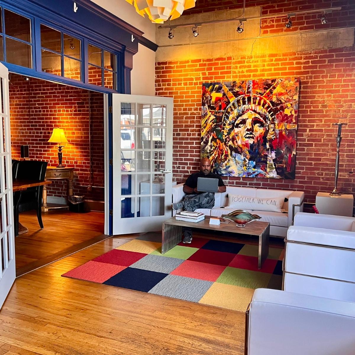 A living room with a vibrant rug and rustic brick walls.