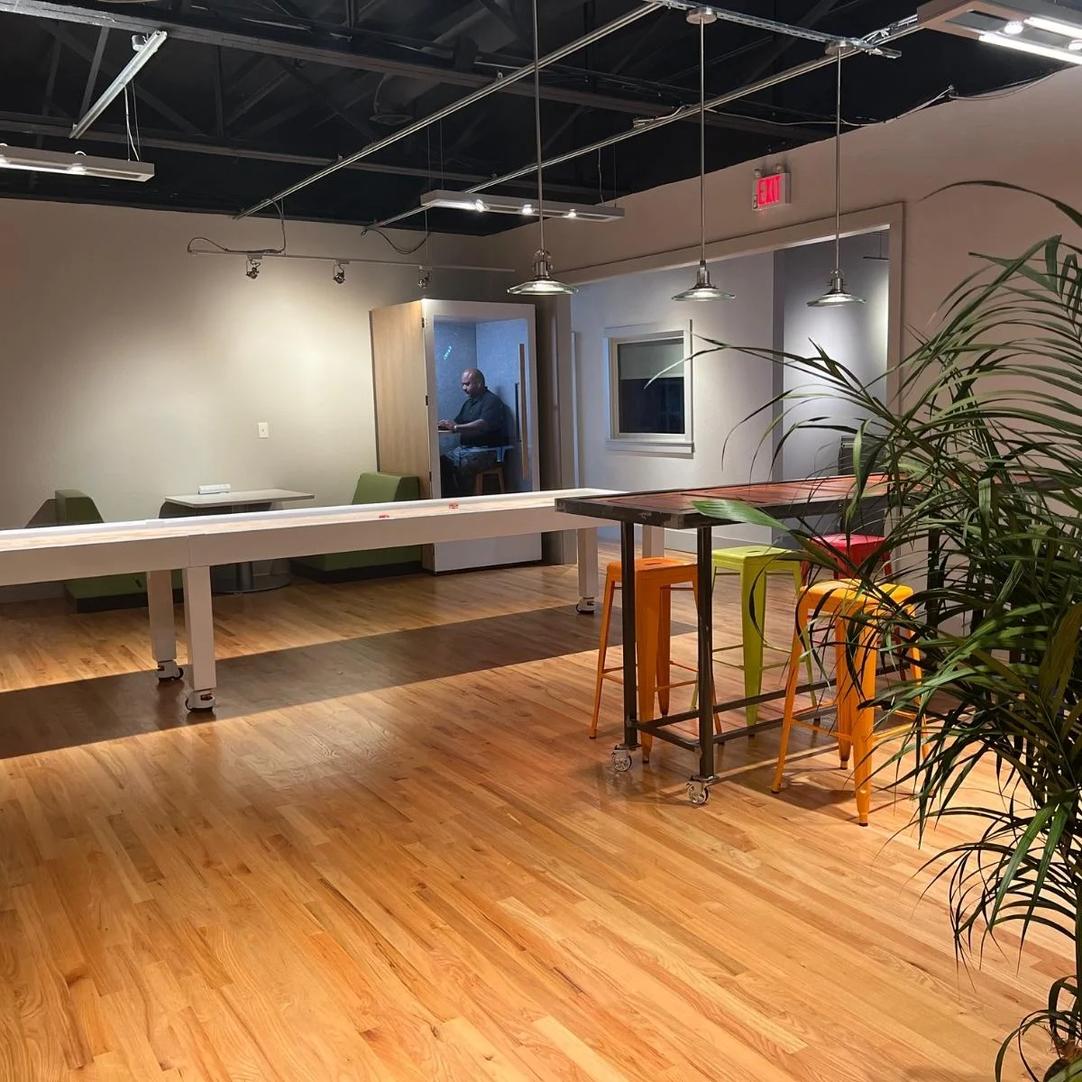 Milton Web Design 1 An office with a table and chairs and a plant designed by Milton.