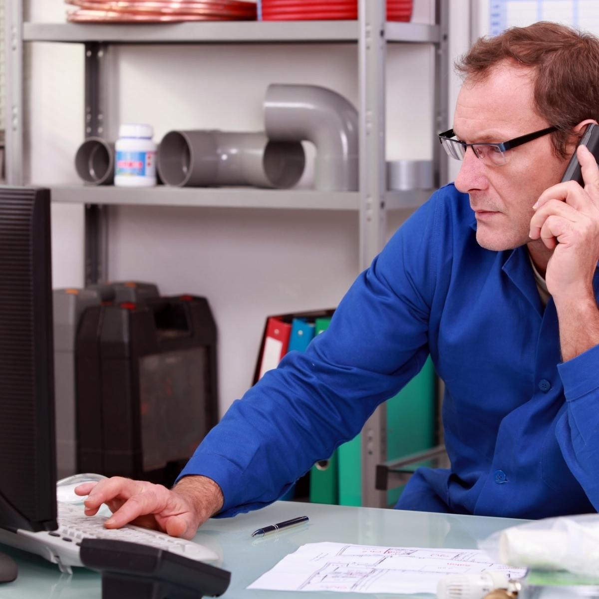 The man is wearing a blue shirt while providing plumber SEO services.