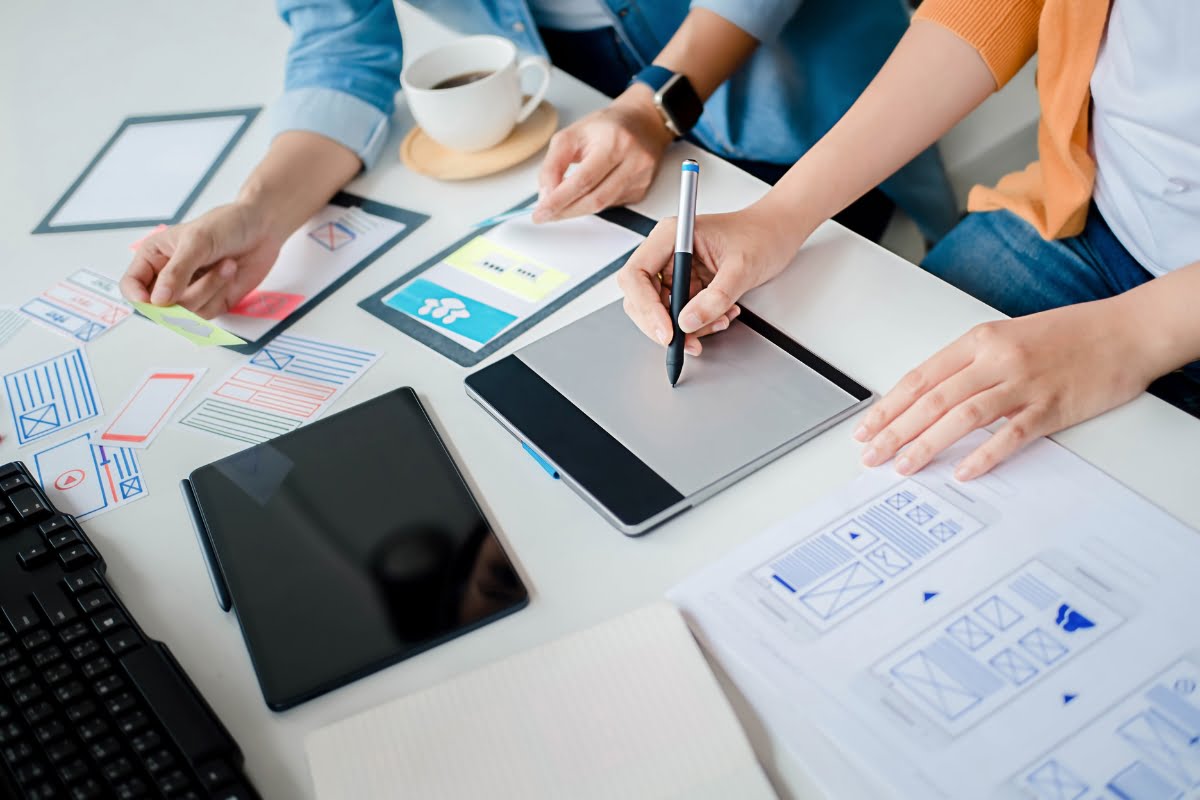 Content Marketing Strategy: The Power of Effective Online Storytelling 5 A group of people working at a desk with paper and pens, collaborating on a content marketing strategy.