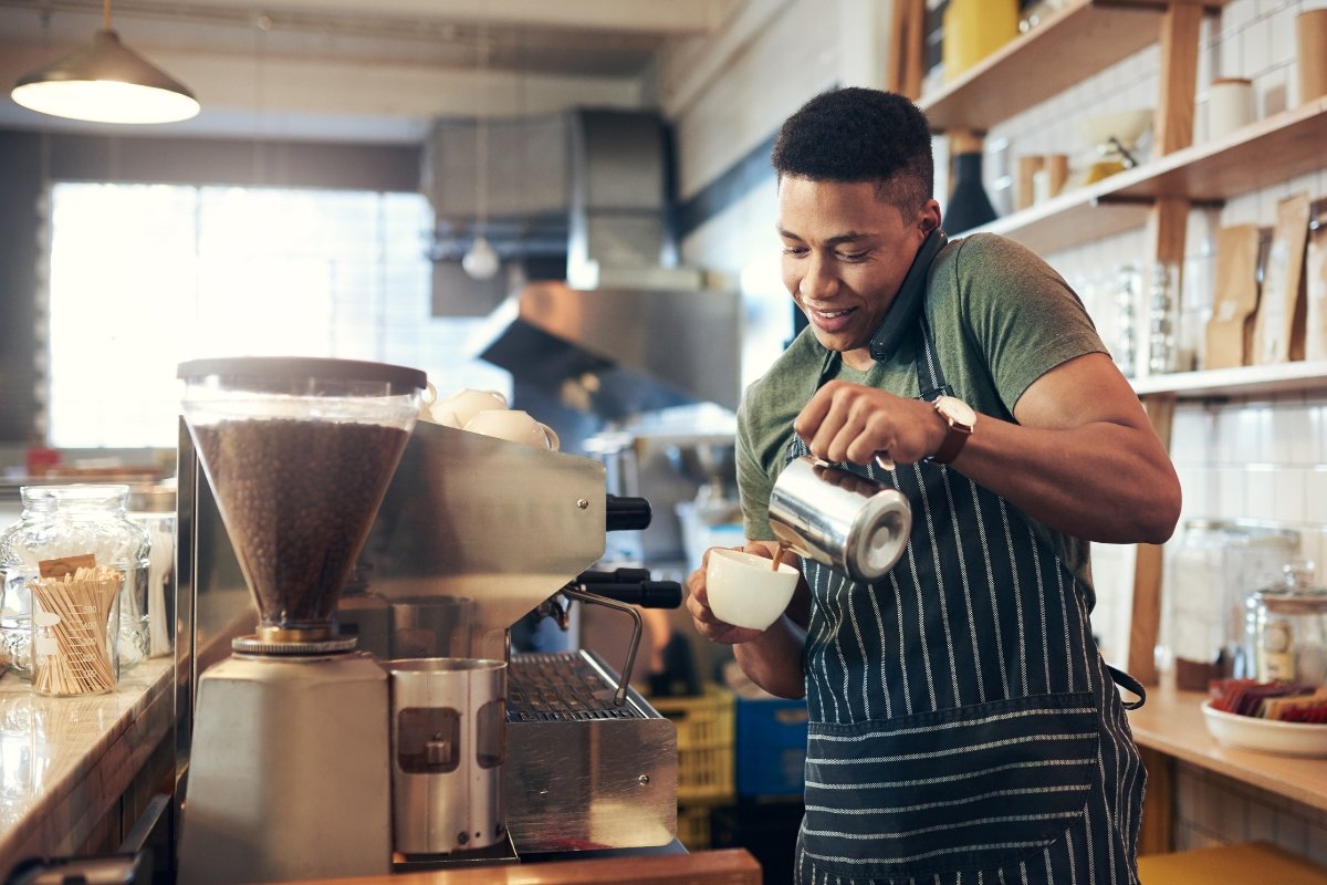 A man in an apron promoting his coffee shop by pouring coffee in a Google My Business post.