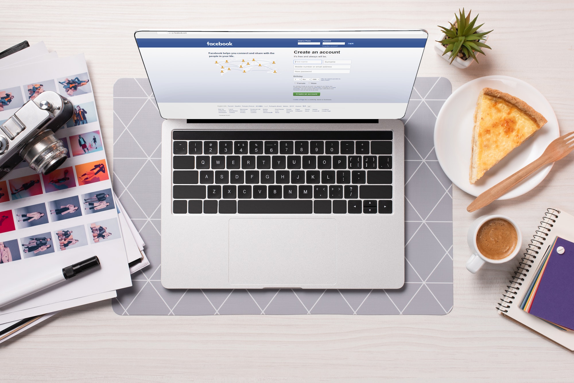 The Pros and Cons of Boosting Facebook Posts 3 office desk with laptop with facebook website on screen, flat lay
