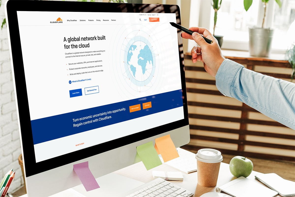 A person is pointing at a computer screen displaying a website to learn about 'what is a cdn'.
