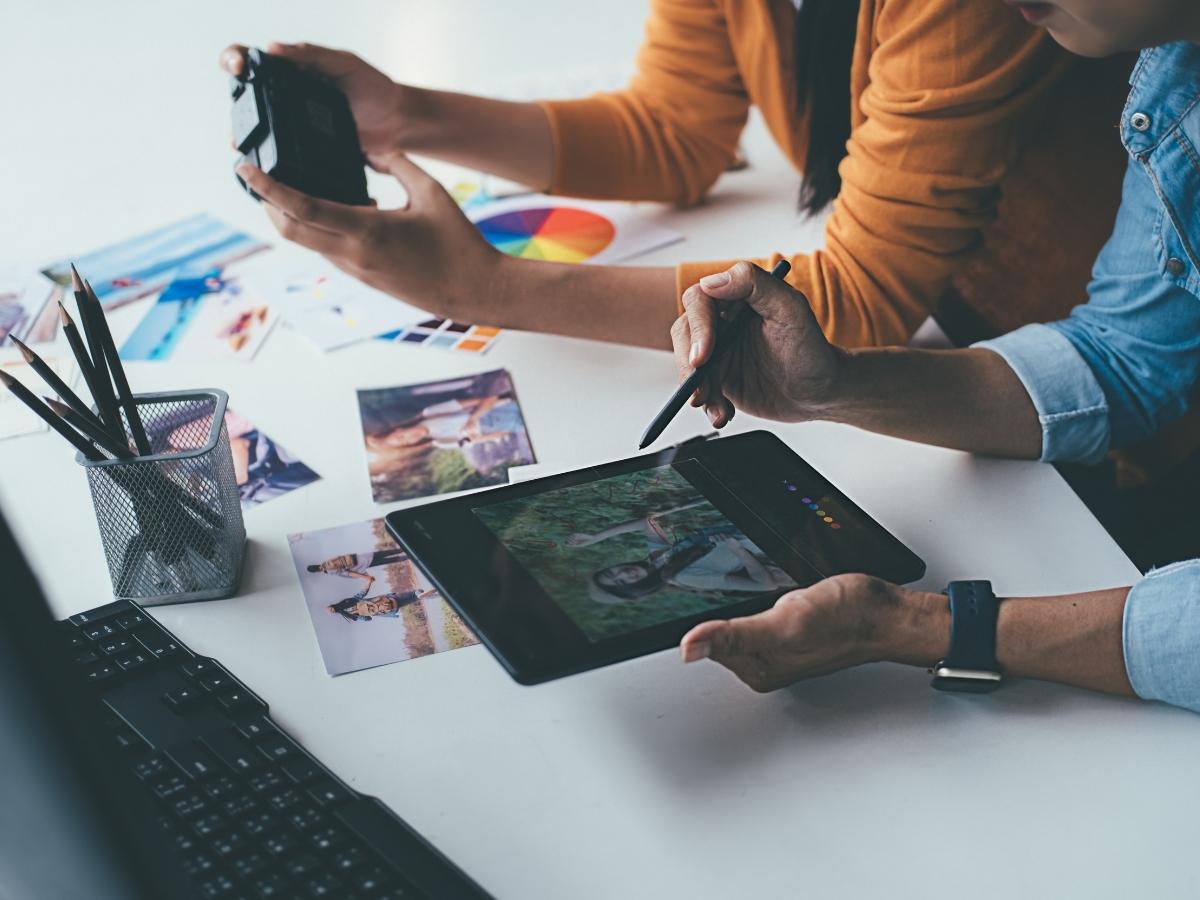 A content marketing agency team collaborating at a desk with a tablet.