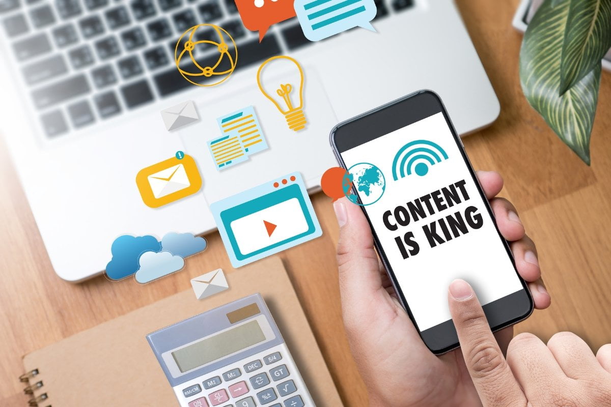 A person demonstrating content syndication by holding a phone with the word "content" on it.