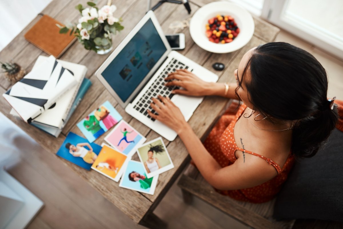 A woman working on her laptop at home while contemplating how many blog posts to write per week.