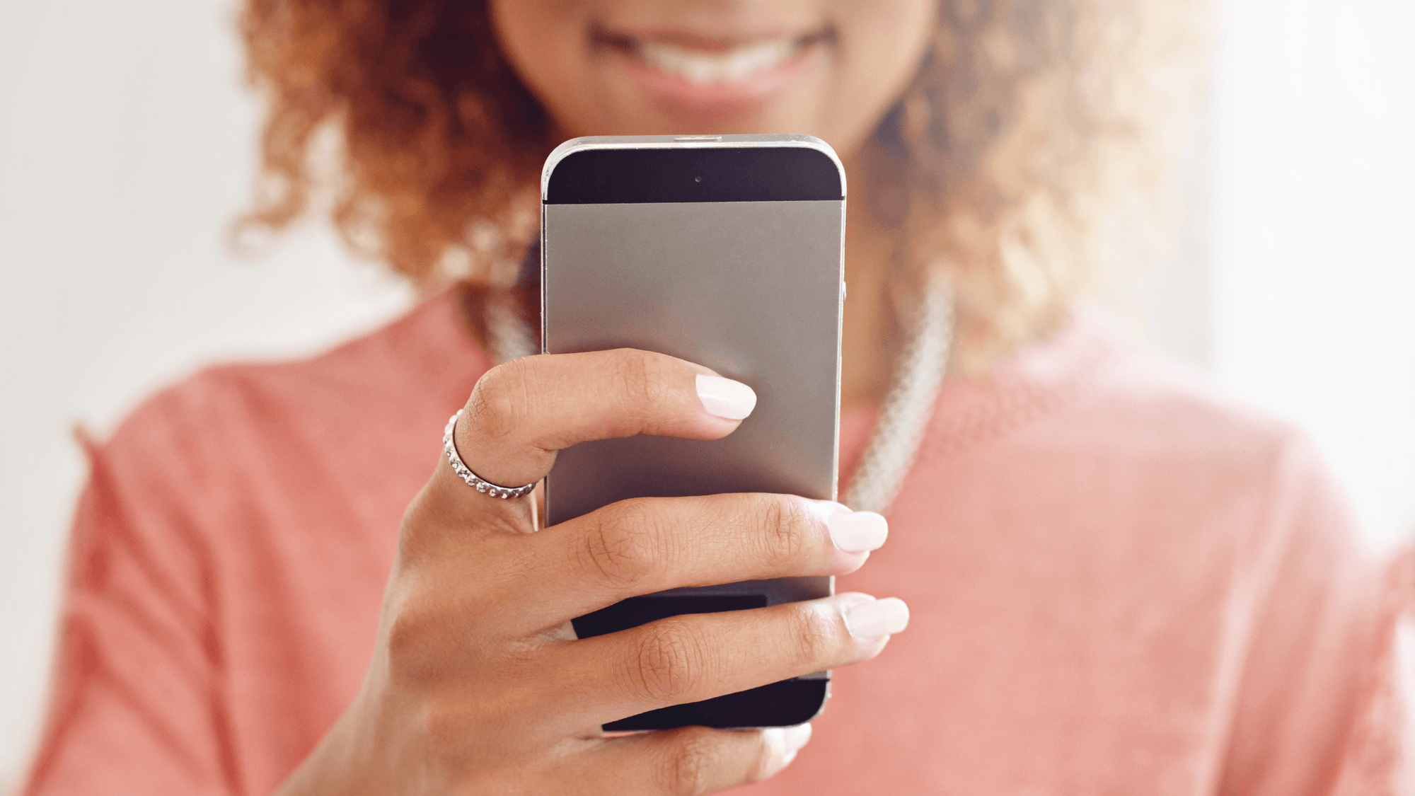 A woman with curly hair using a mobile phone.