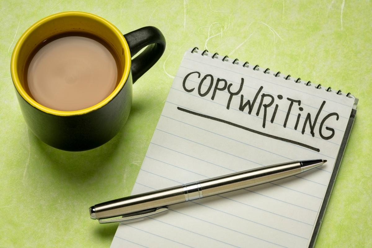 A notepad with the word SEO copywriting next to a cup of coffee.