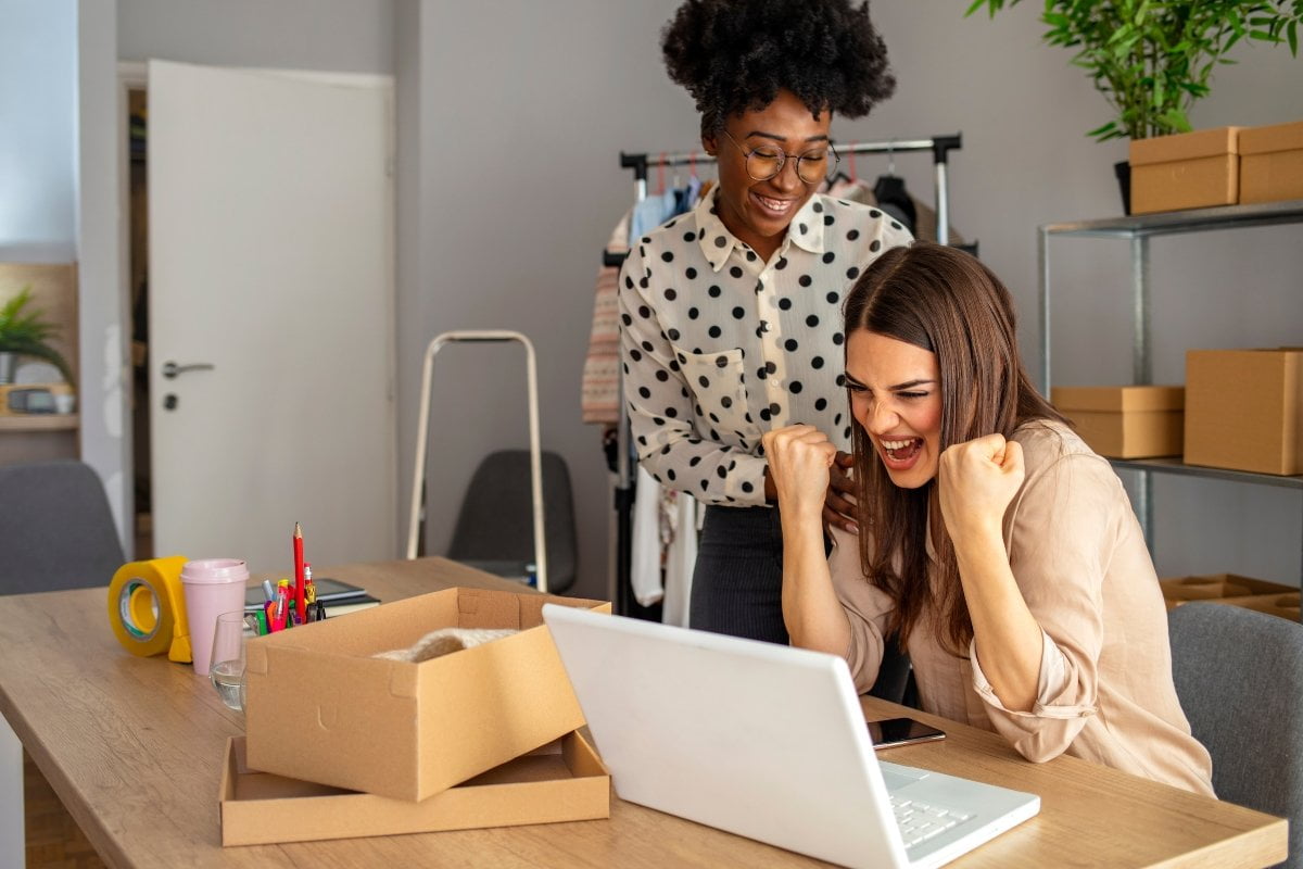 Two women utilizing Google Maps on a laptop in an office.