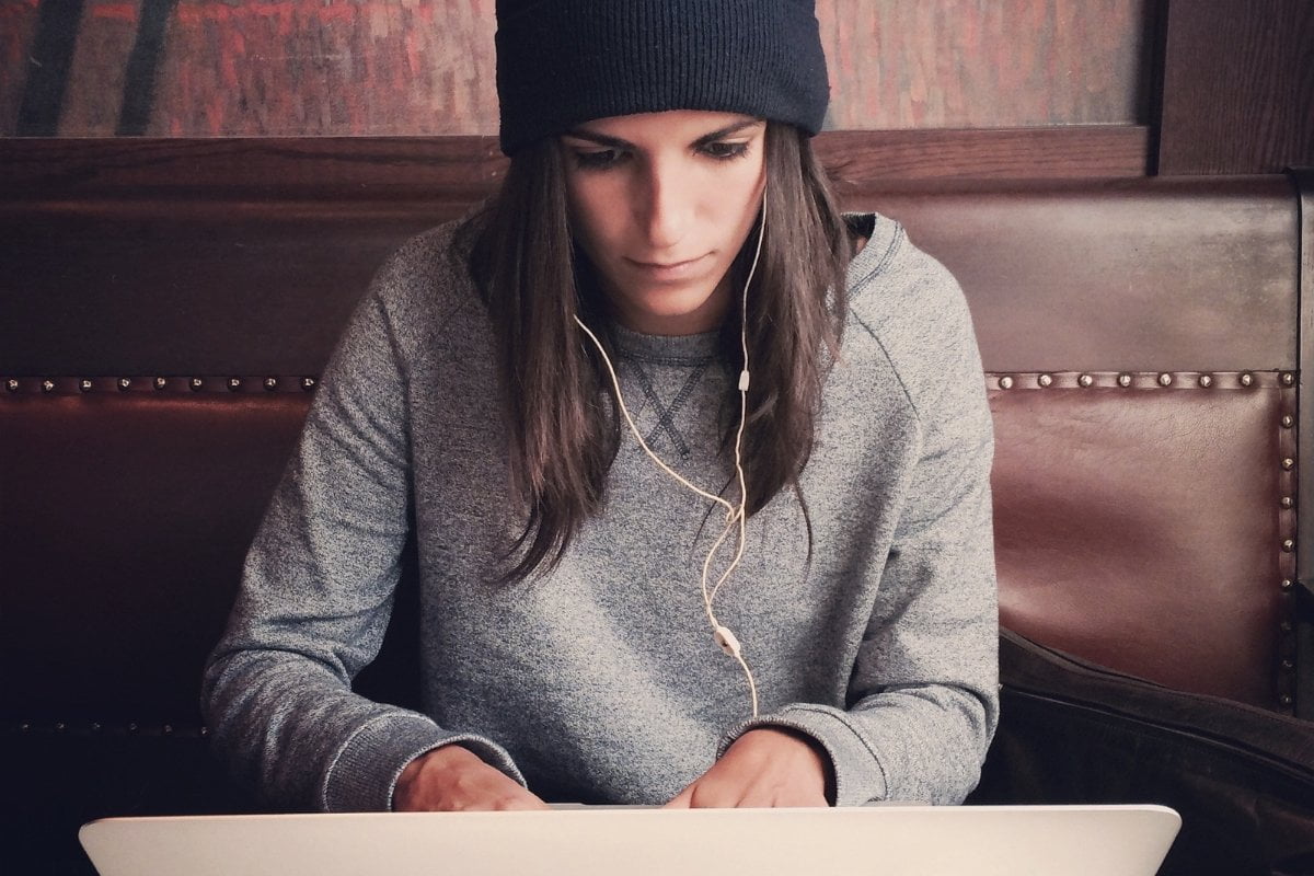 A woman wearing a beanie and listening to music on her laptop, showcasing custom favicons.