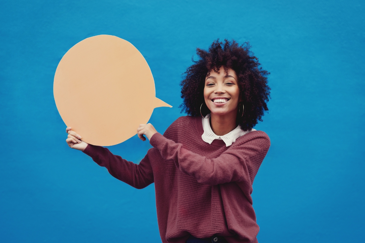 Word of Mouth Marketing: The Power of Personal Recommendations 1 Woman holding a "word of mouth marketing" speech bubble against a blue background.