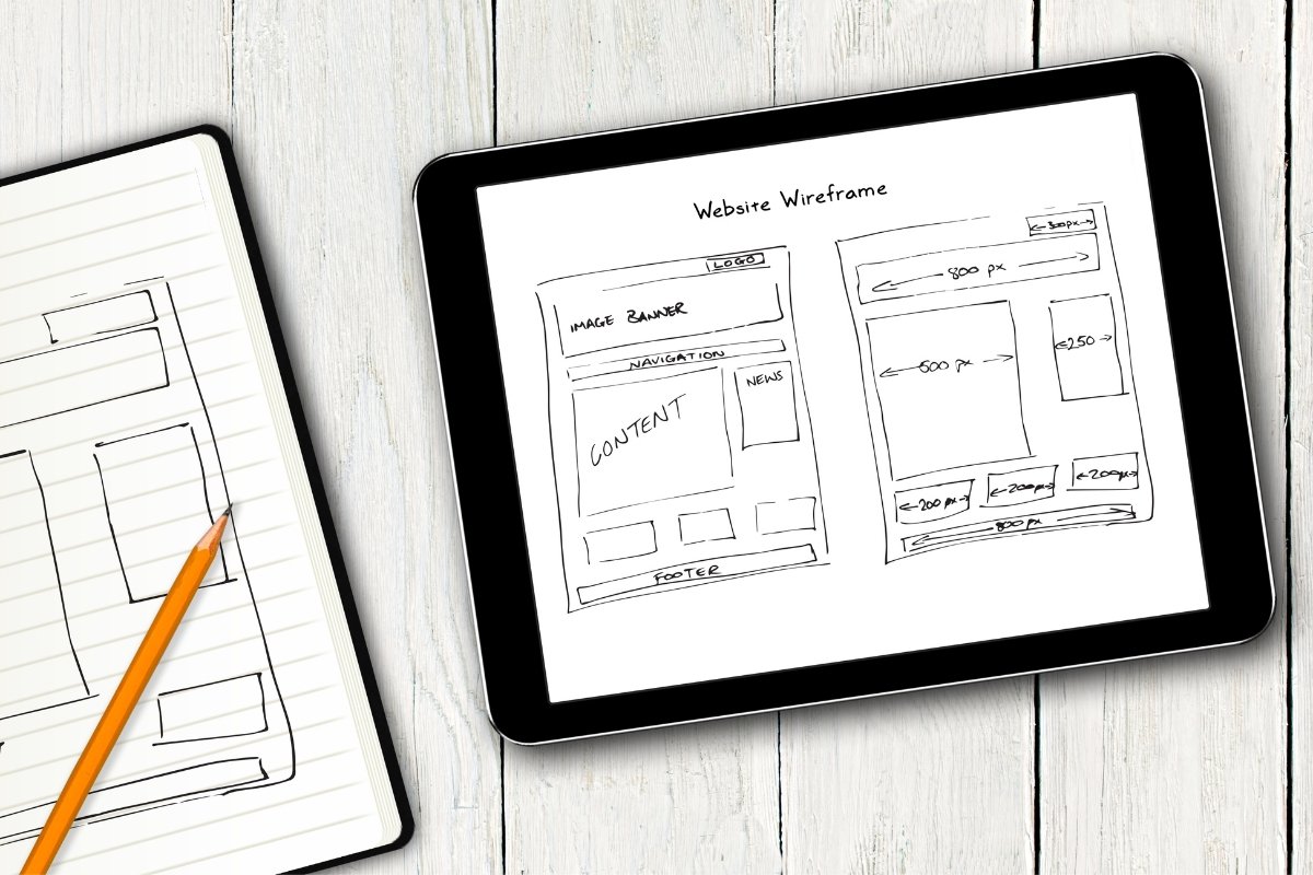 A tablet featuring a notebook and pencil, representing the website design process.