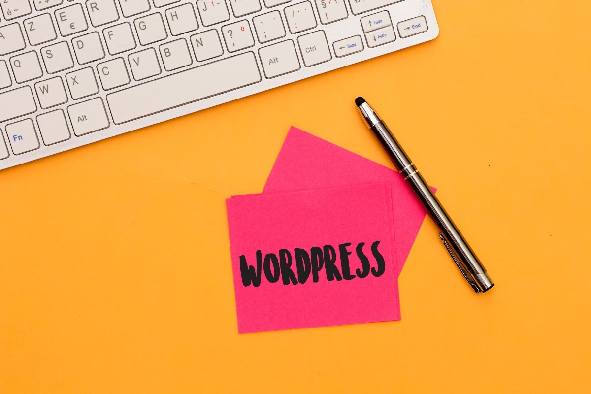 A pink post it note with the word wordpress on it next to a keyboard during the installation process.