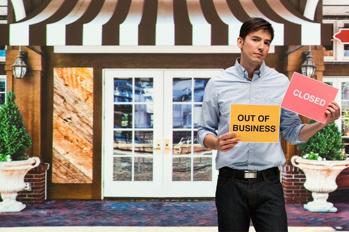 A man holding a sign that says close out of business seeks guidance on removing a business from Google Maps.