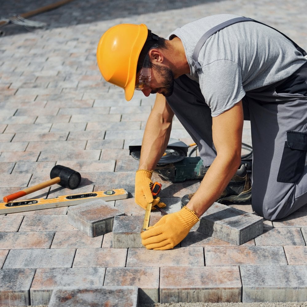 A construction worker is building a sidewalk.