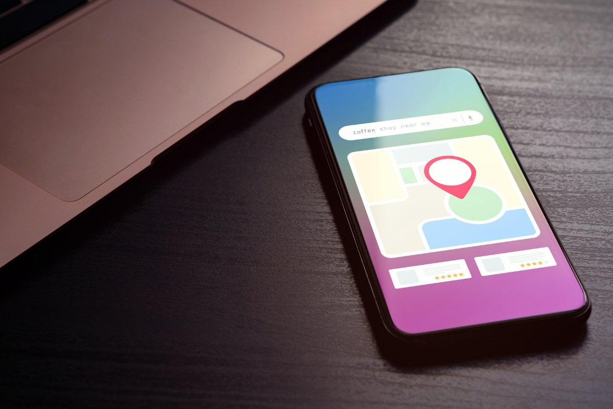 A smartphone with a GPS pin and a laptop for local search.