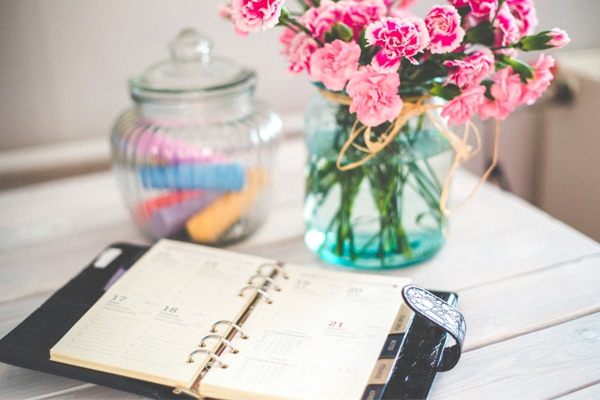 A floral notebook with a jar on a table for appointment scheduling.