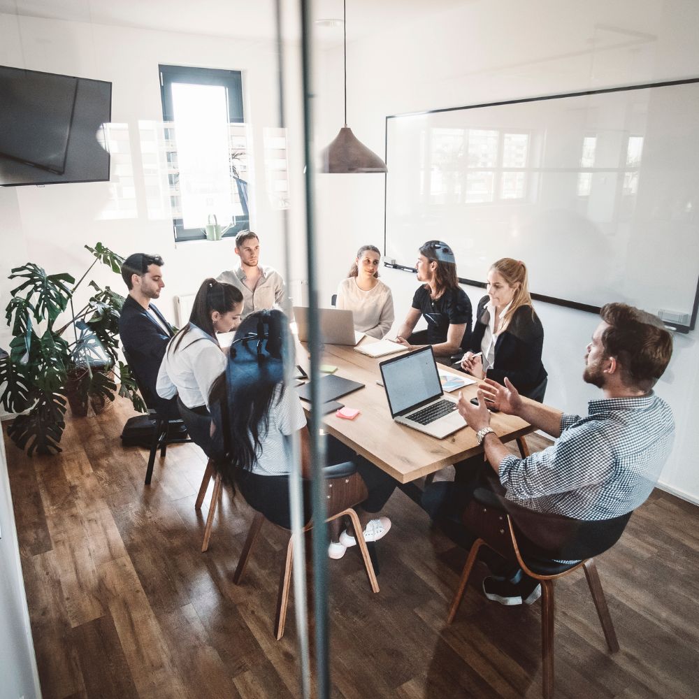 A group of people utilizing marketing automation sitting around a table in a conference room.