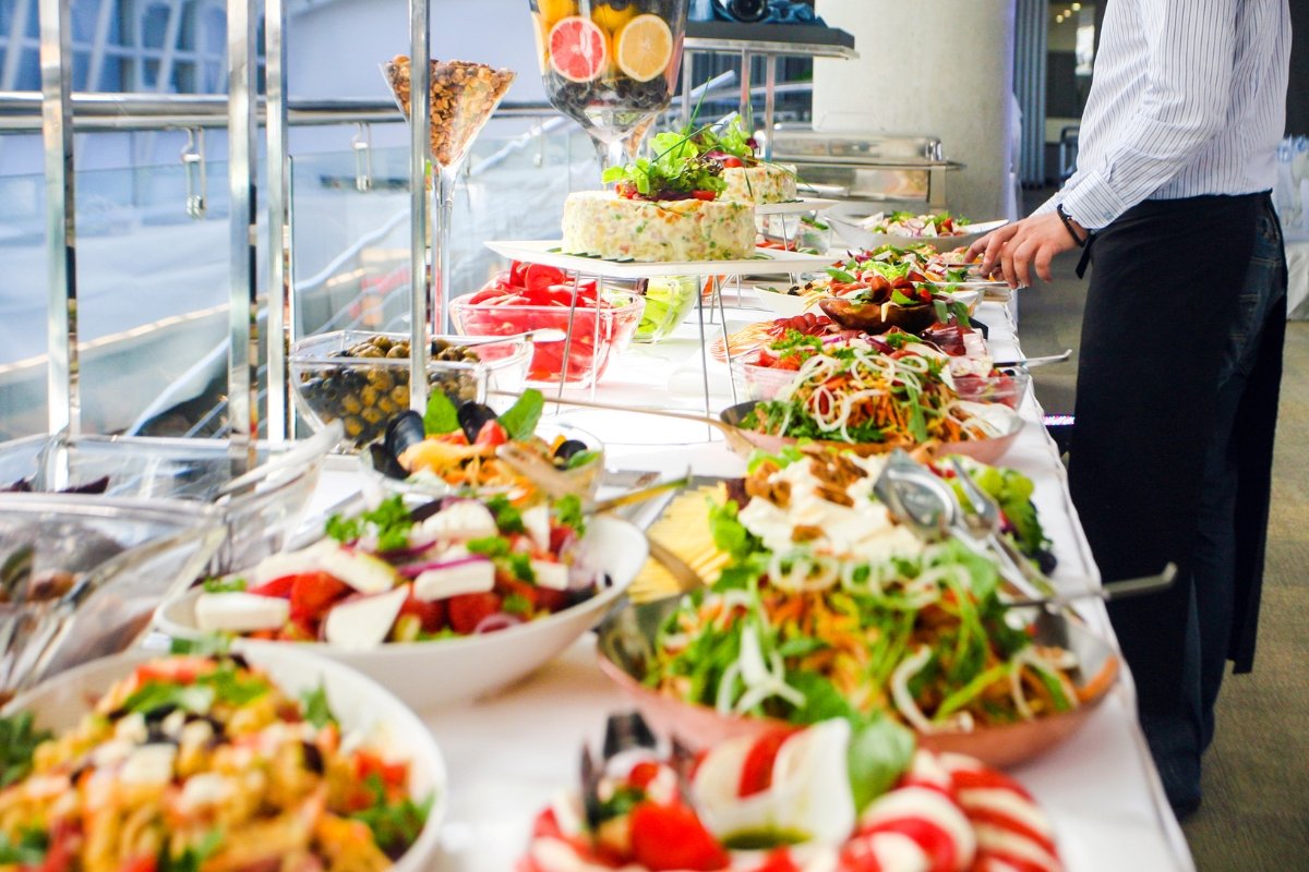 Boost Your Catering SEO with Stellar Reviews 2 A man is standing in front of a catering buffet.