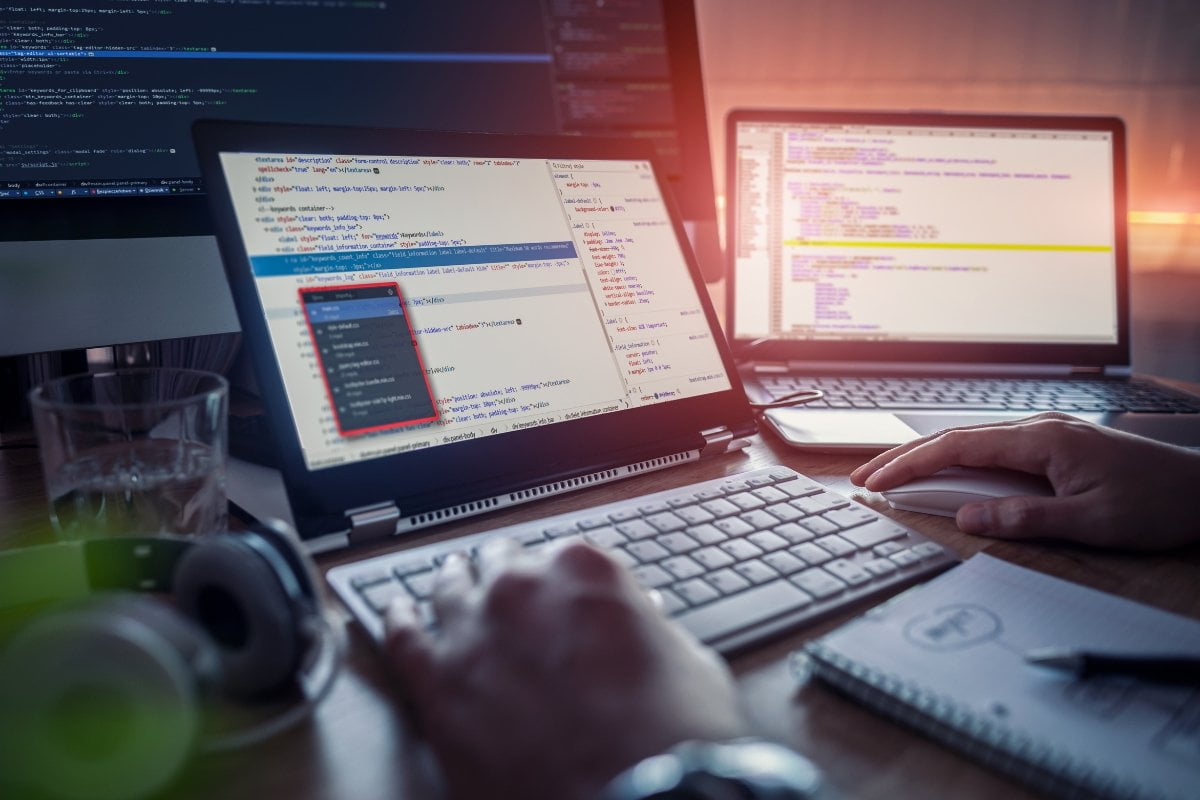 A person is working on a computer with code on staging sites.