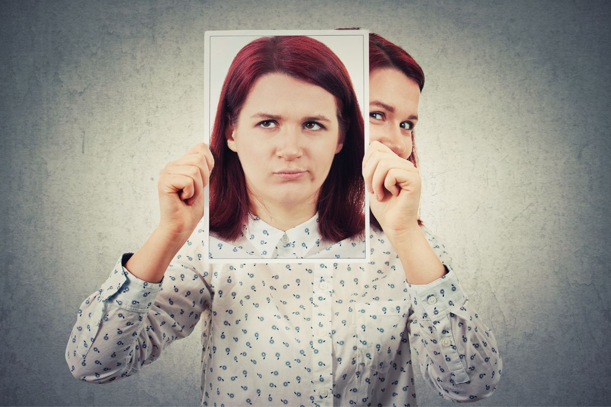 A woman is holding up a fake picture of her face.