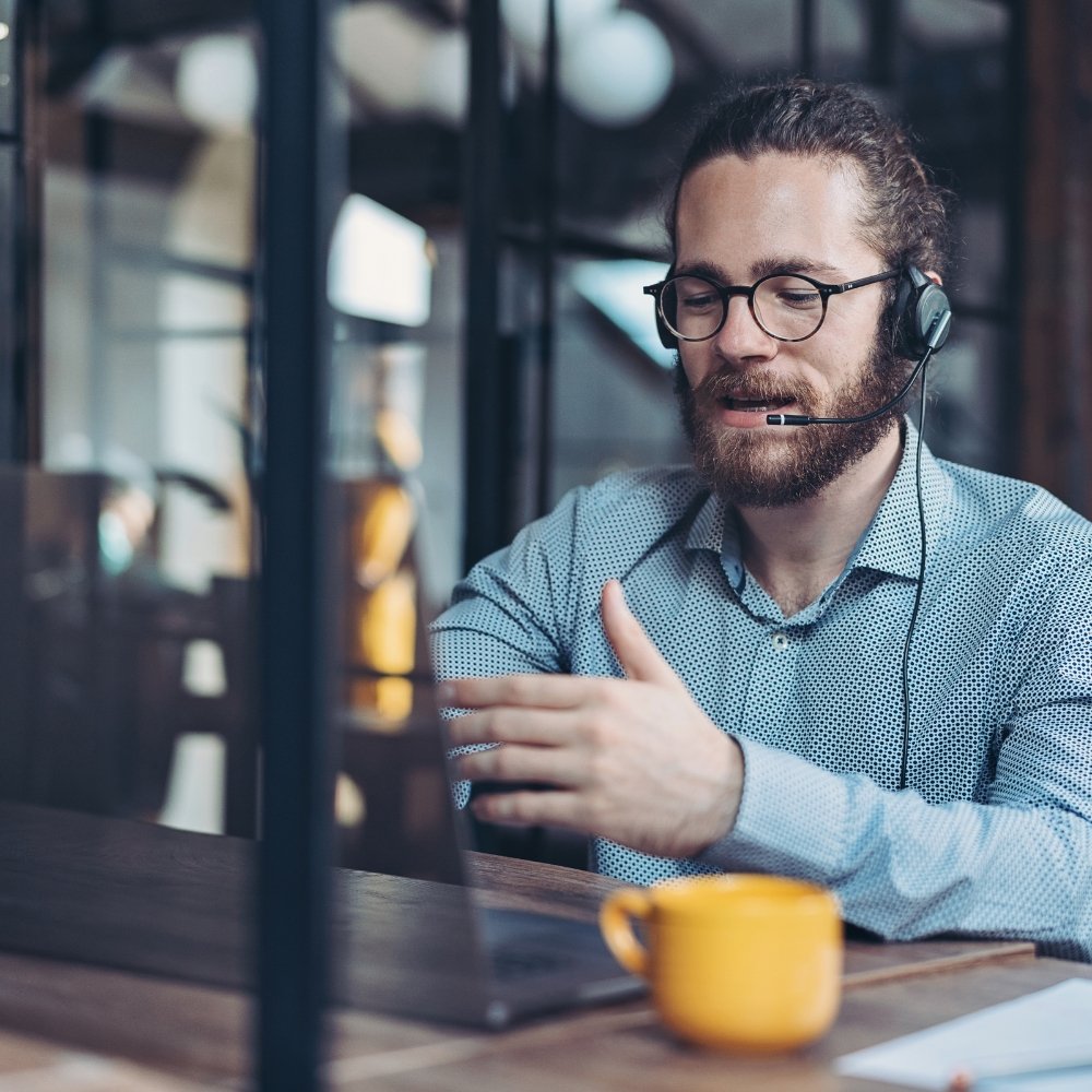 A wordpress expert performing woocommerce maintenance and support while wearing a headset and working on a laptop.