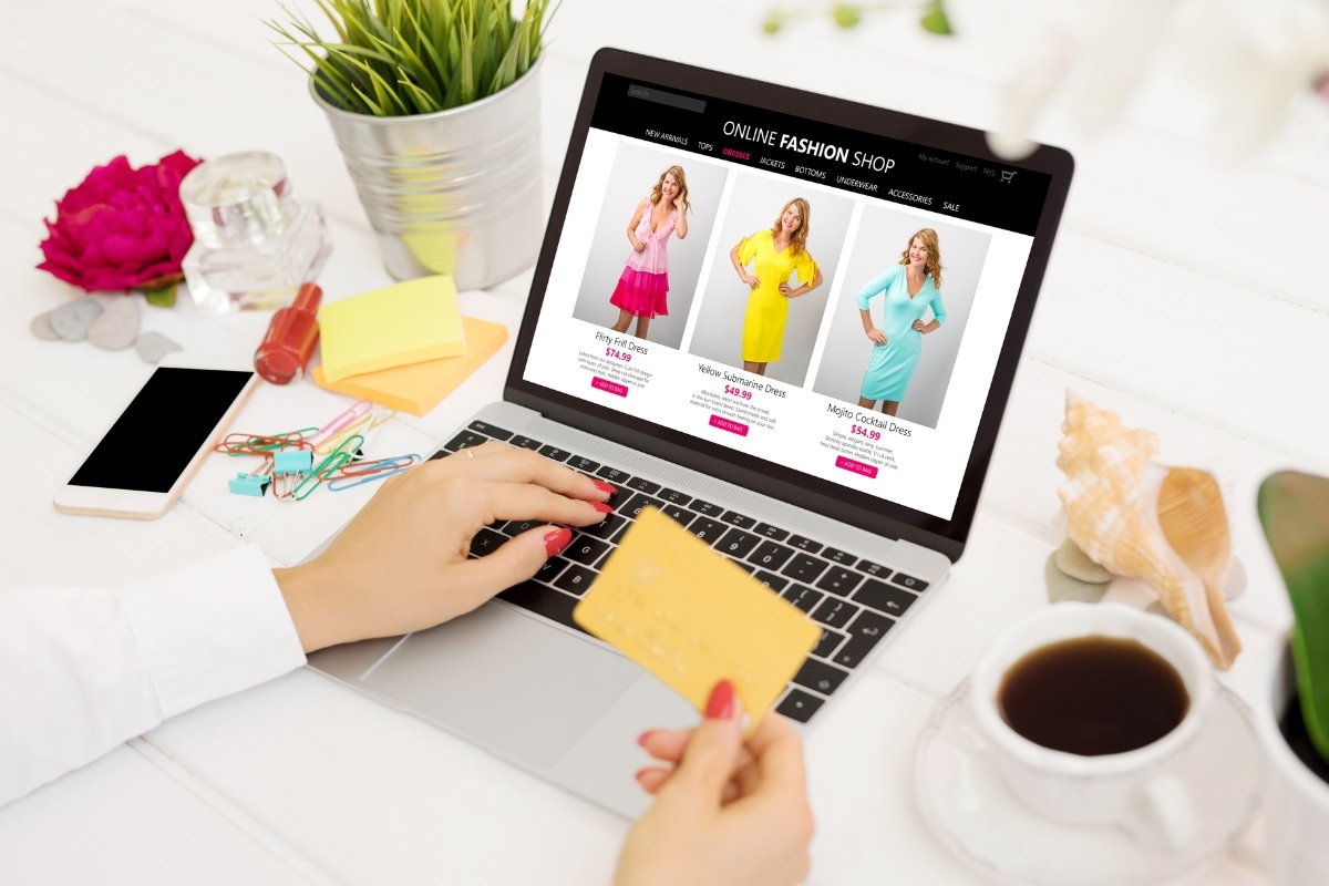 A woman is using a laptop to optimize her online fashion store.