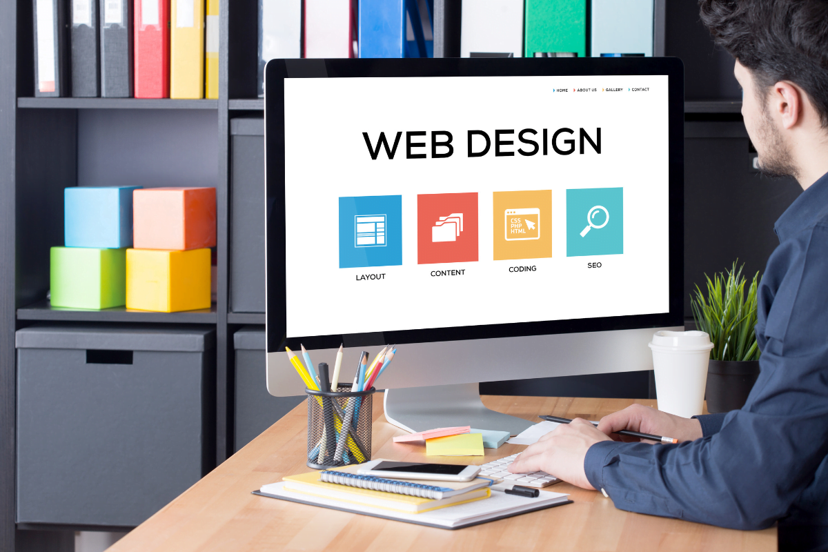 Simplicity In Web Design: Tips For Creating A Simple And Elegant Site 3 A man embracing simplicity in web design while looking at a computer screen.