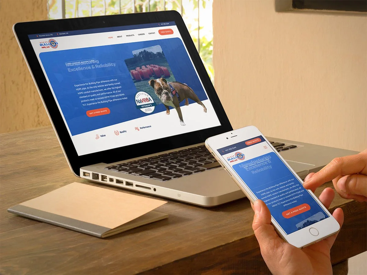 A person using a laptop and cell phone to view a Bulldog Pipe website.