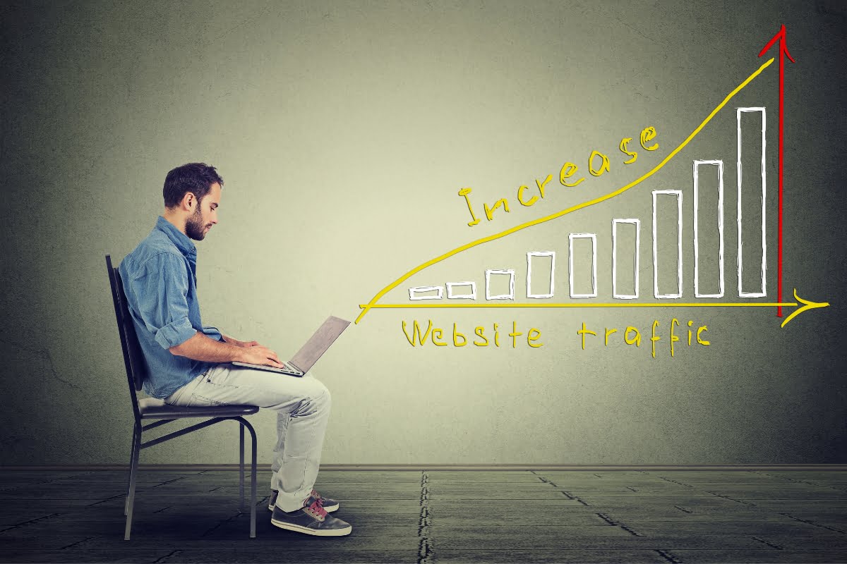 Exploring Website Traffic Sources for Success 3 A man analyzing website traffic sources on his laptop while sitting on a chair.