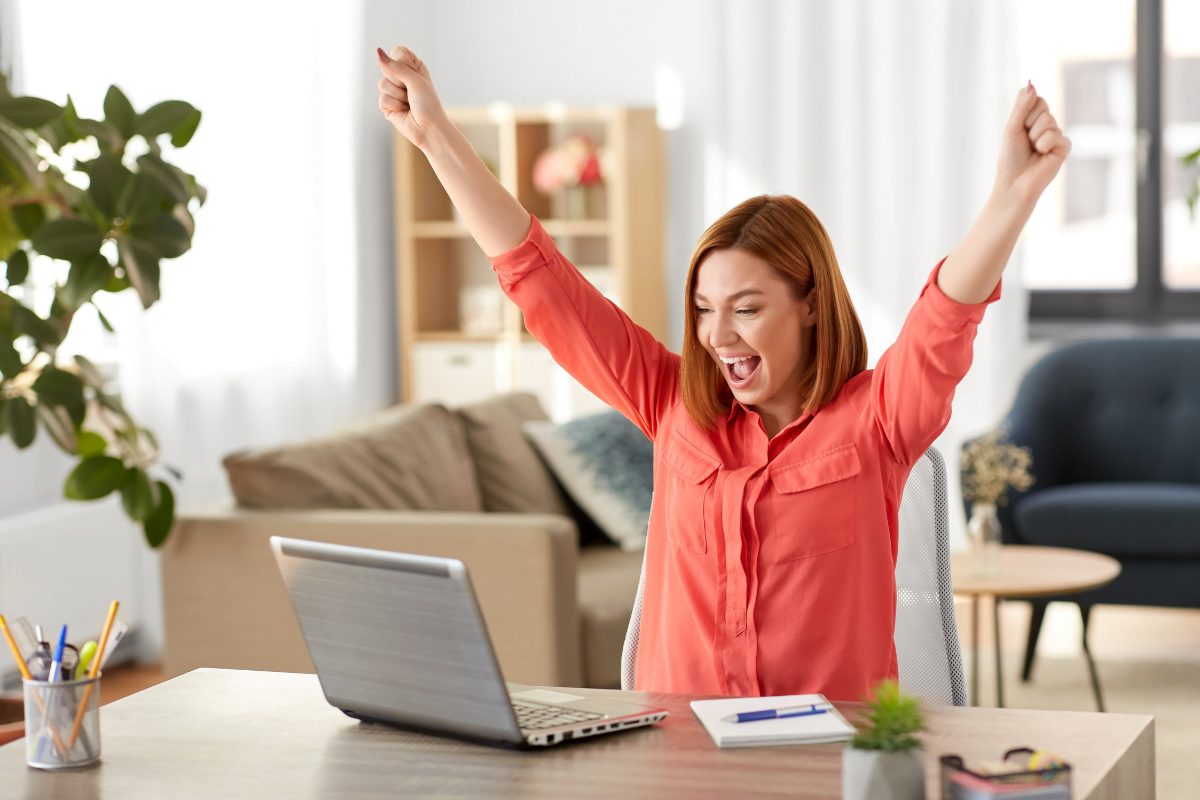 The Power Of Semantic Search In SEO: Cracking The Code 4 A happy woman is raising her hands while using a laptop due to better search engine ranking.