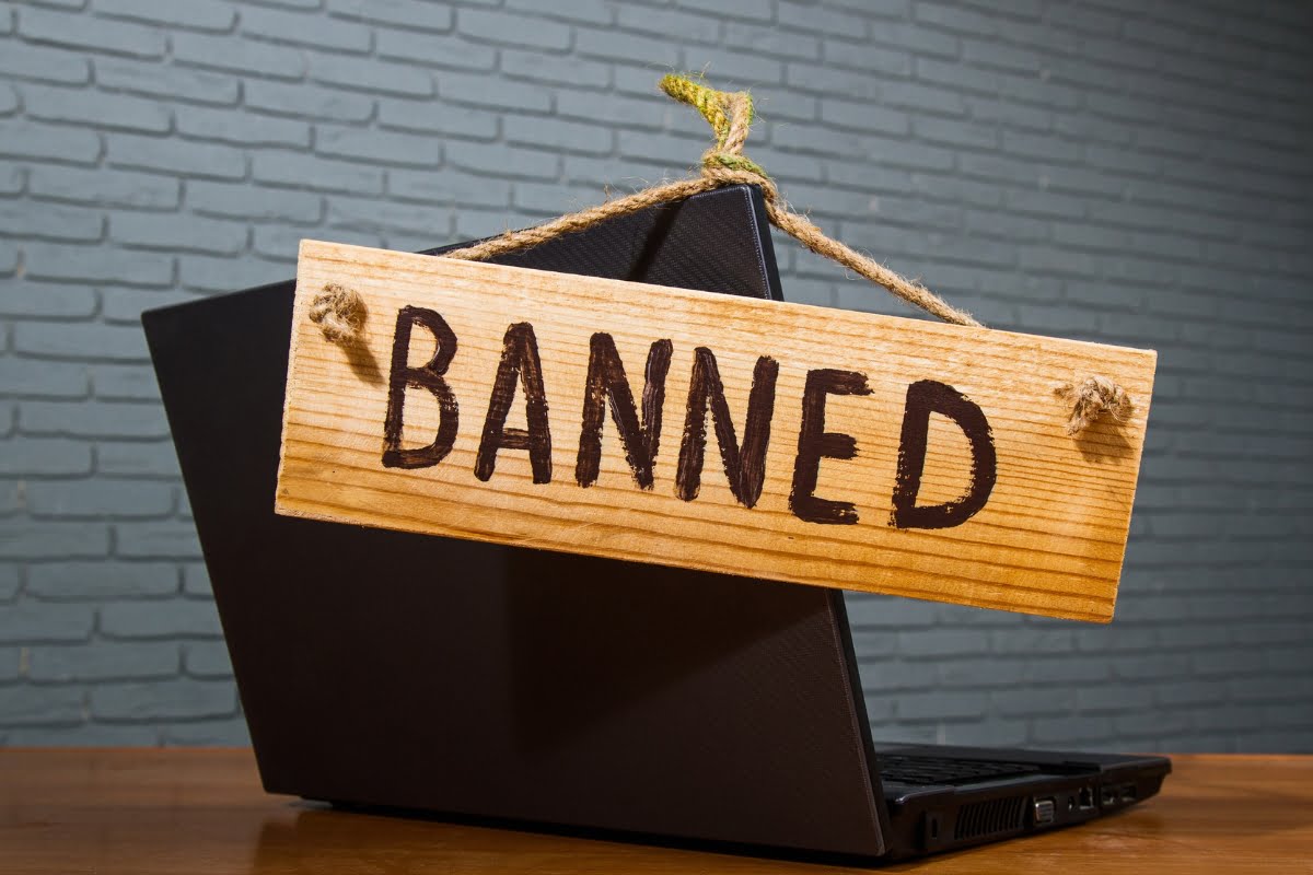 Shadow Banning on Social Media 5 A laptop showcasing shadow banning with the word banned hanging on it.