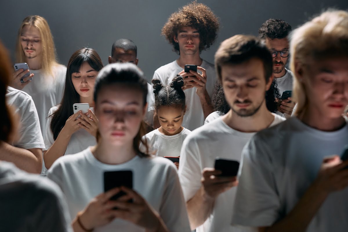 Shadow Banning on Social Media 7 A group of people in white t-shirts are looking at their phones, unaware of the shadow banning.