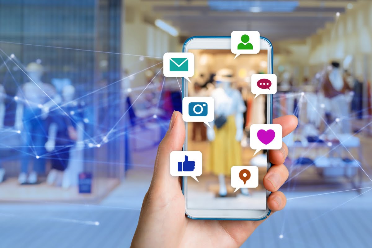 Shadow Banning on Social Media 2 A hand holding a smartphone with shadow banning icons on it.