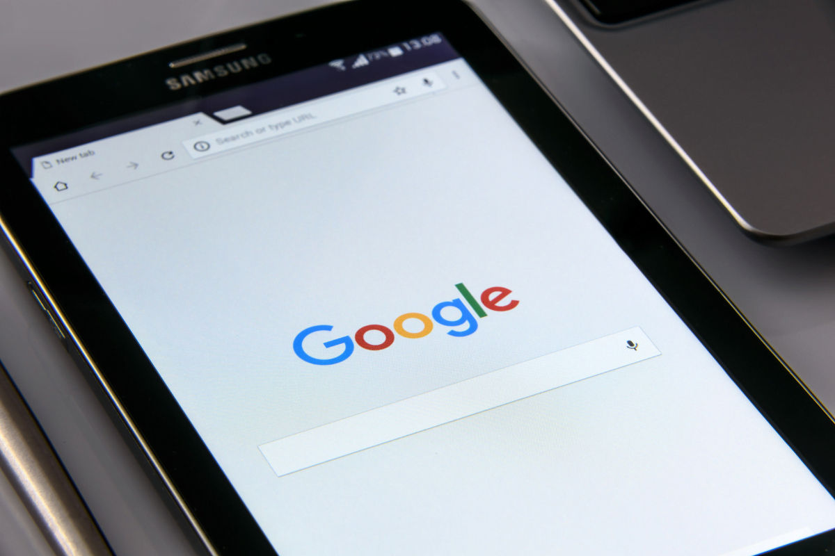 The Google logo is displayed on a tablet computer for Google Business Profile.
