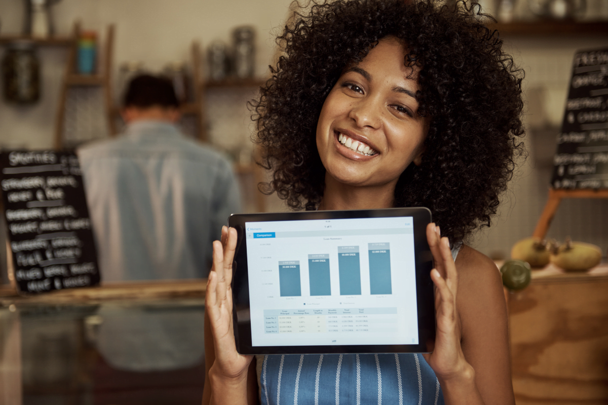 Get Noticed: GMB Services For Business Growth 5 A woman is holding up a tablet displaying a graph of her business growth.