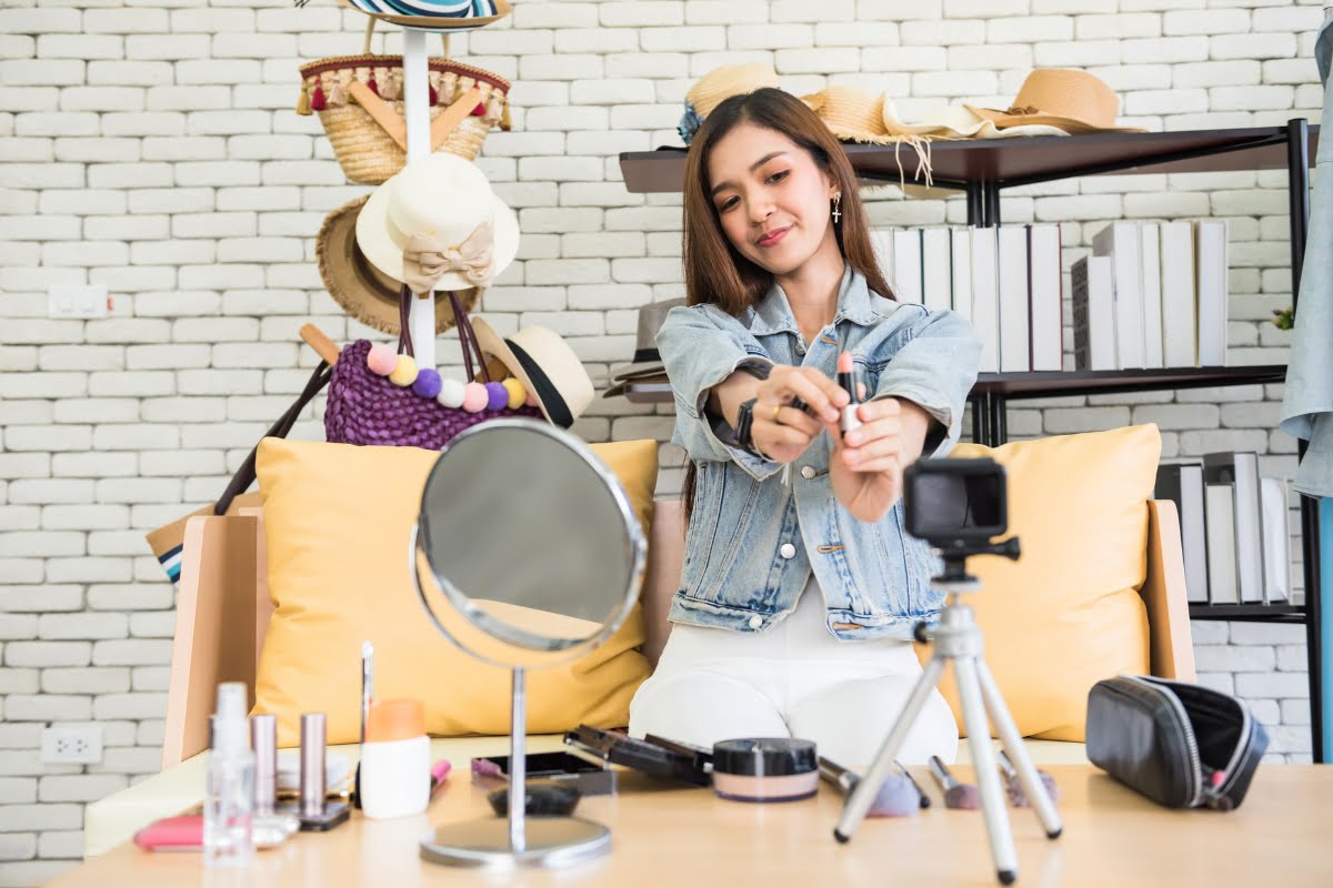 The Power of Influencer Marketing: How to Win Over Your Target Audience 4 A young woman is engaging in influencer marketing while sitting on a couch with a camera in her hand.