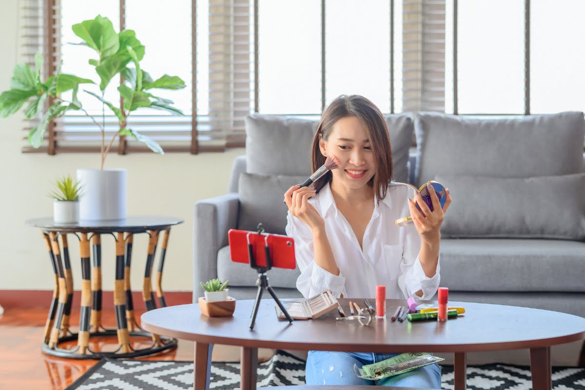 The Power of Influencer Marketing: How to Win Over Your Target Audience 2 A woman is utilizing influencer marketing while sitting on a couch with a cell phone in her hand.